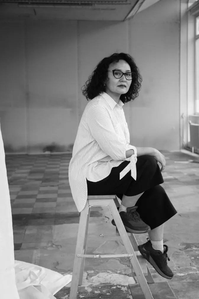 Portrait of a seamstress seated in the workshop