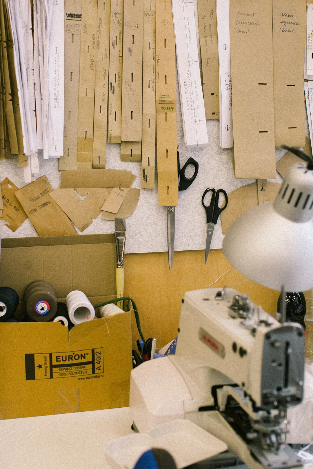 Threads, scissors, and tools at a sewing station
