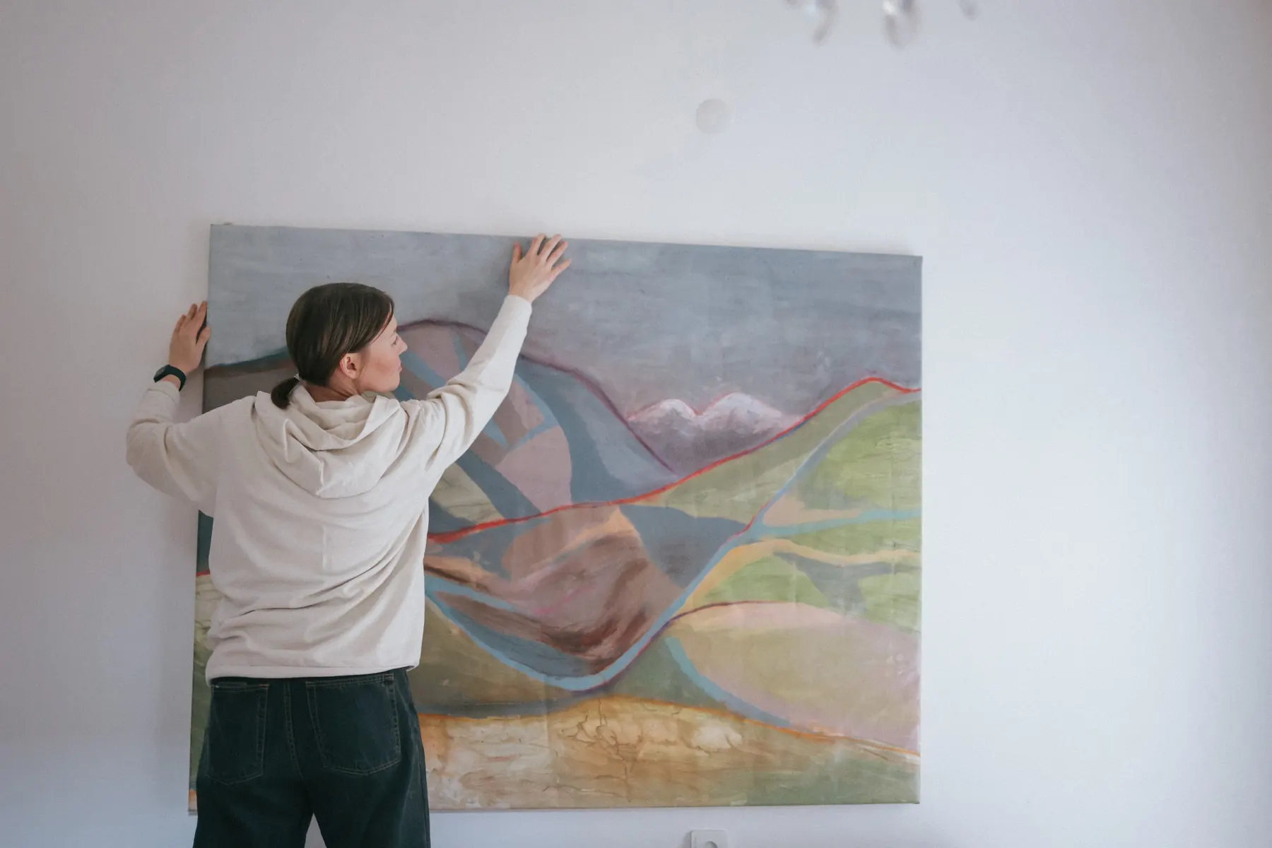 Hands adjusting the work on the wall
