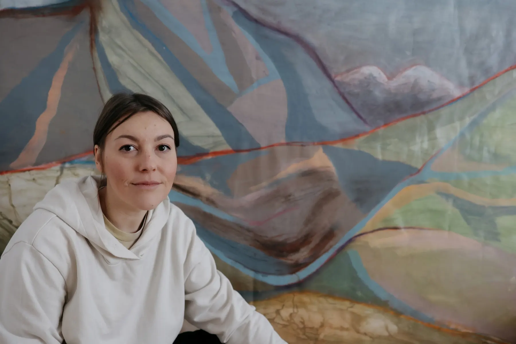 The artist in front of a large landscape work
